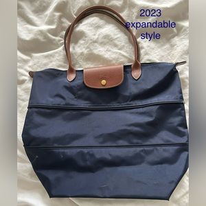 Zip inset expands/contracts,  rich brown leather trim, zip closure, snap flap